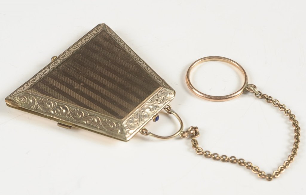 GOLD-FILLED PURSE-SHAPED DUO COMPACT: Chain handle with finger ring, monogrammed on one side, framed mirror in the lid, two hinged powder wells in the base, marked on the underside of one lid, measures 1.75 x 2 inches.