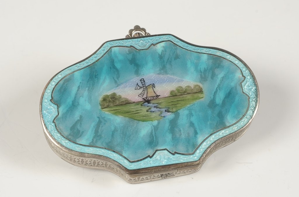 DFB CO. GUILLOCHE ENAMEL VANITY CASE W WINDMILL: Blue guilloche and enamel with a hand-painted windmill on top, hinged finger ring on the bottom, framed mirror in the lid, base holds wells for rouge, powder and a hinged lipstick, marked on the mirro