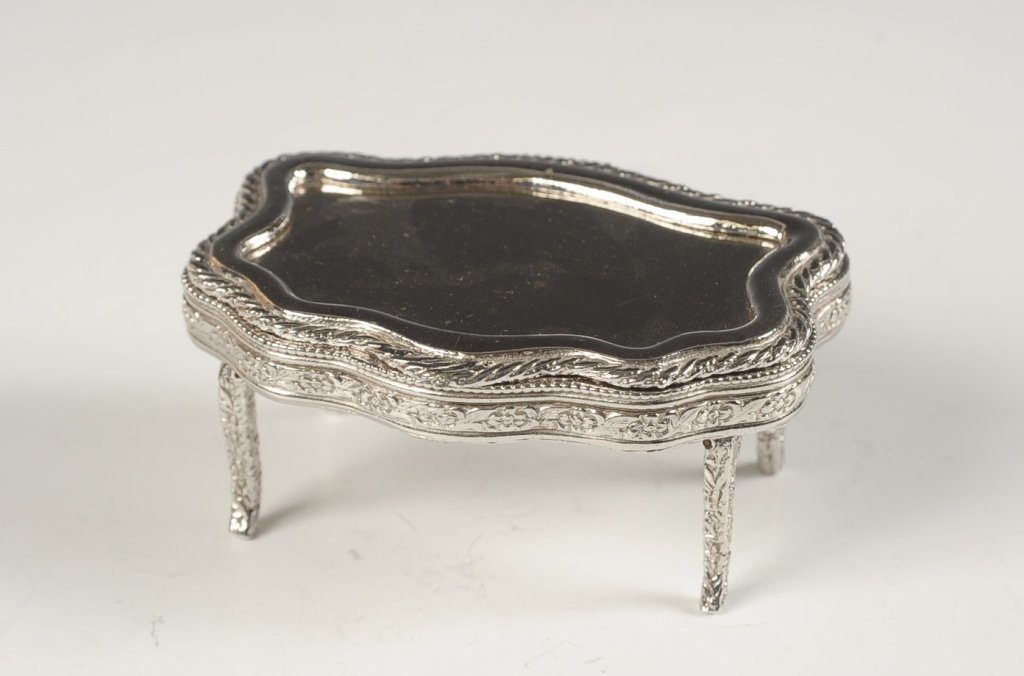 VOLUPTE COMPACT SHAPED AS A VANITY DRESSER: Silvertone vanity case with fold out legs shaped like a vanity table, framed mirror in the lid, shaped sifter and branded puff, marked on the bottom, measures 1.5 x 3.5 x 2.5 inches with the legs unfo