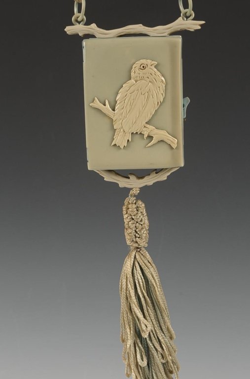 VINTAGE PLASTIC VANITY CASE WITH BIRD MOTIF: Light blue vanity case with ivory branches and bird motif, braided cord handle and tassel, hinged mirror, wells for powder and lipsticks, measures 4 x 2.5 inches, 20 inches from handle to tassel.