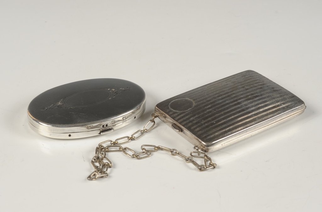 W.M. CO. MINIAUDIERE, PLUS A COMPACT: W.M. Co. miniaudiere with a chain handle, money clip in the lid, hinged writing pad over a powder well, change holders for nickels and dimes, measures 3.75 x 2.5 inches, good. Plus an oval compact wit