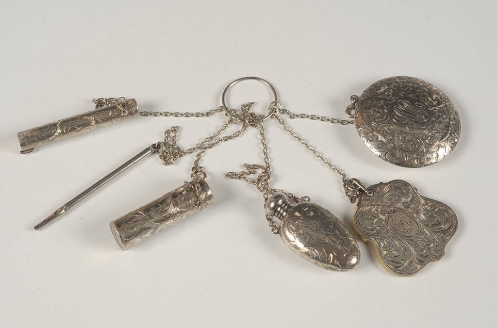 CHASED STERLING CHATELAINE: Six chains on a finger ring with compact, lipstick, mechanical pencil, perfume, notepad and another lipstick, one page of the notepad is written 'Dec. 22, 1912 From Eva & Jesse To Fannie,' monograms t