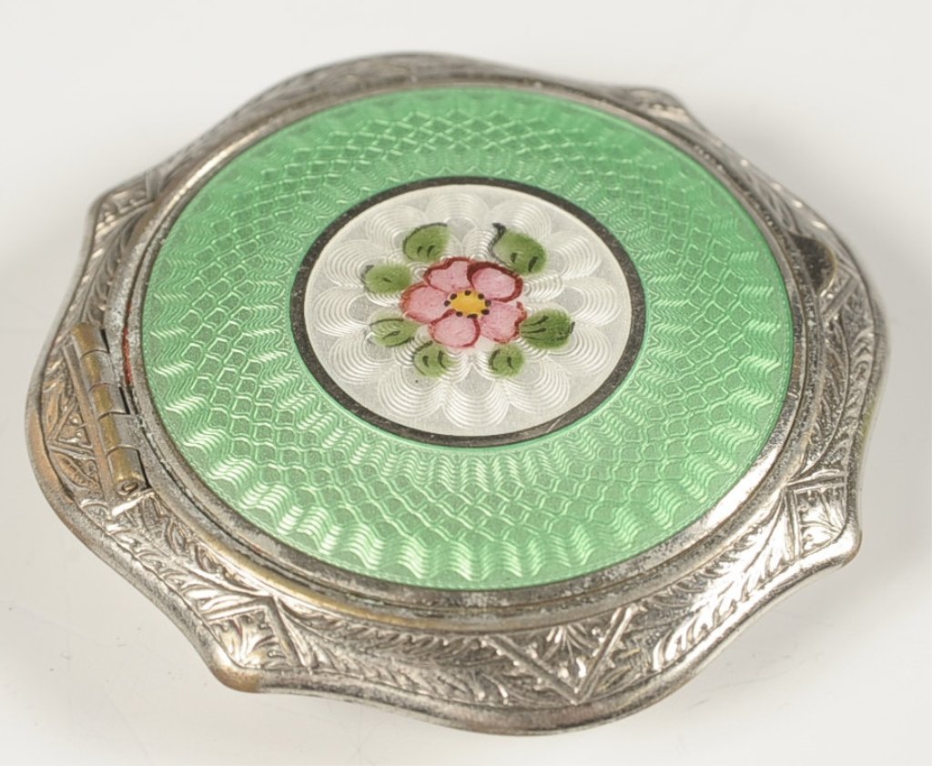 GREEN AND WHITE GUILLOCHE COMPACT: With a painted floral, silvertone compact with rouge well in the lid surrounded by a polished metal mirror, rotary sifter in the base with a puff, unmarked, measures 2.25 inches.