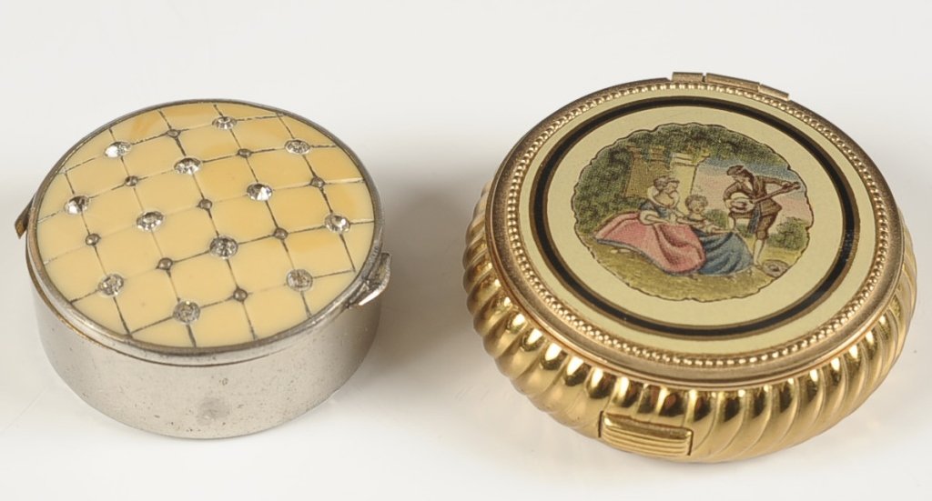 EVANS TAP-SIFT & A PLASTIC & CRYSTAL TOPPED COMPACT: Evans enamel on goldtone compact with a printed scene on the top, framed mirror in the lid, tap sifter in the base, branded puff and original instructions present, measures 2 inches, unused condition.