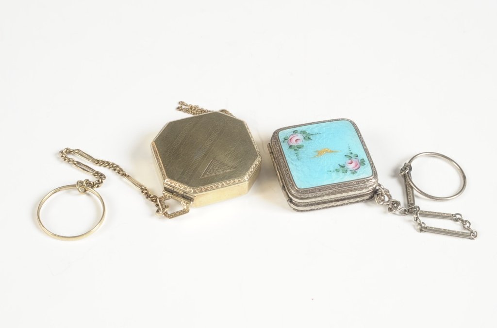 TWO SMALL COMPACTS W FINGER RINGS, ONE STERLING: Guilloche compact with gold bird and painted roses, chain with finger ring, framed mirror in the lid, base holds a rouge well with pan over a powder compartment with rotary sifter, unmarked, measures 