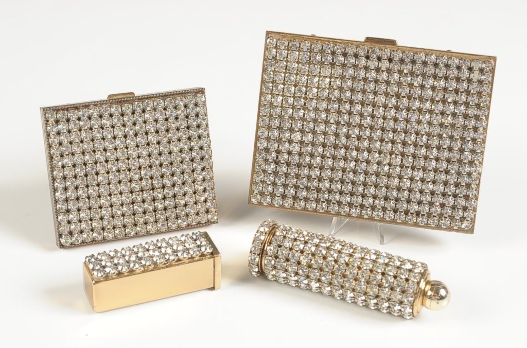 CRYSTAL PAVE VANITY SET: Four pieces in goldtone with pave crystals: cigarette case, compact, perfume and lipstick combo and another lipstick with mirror, range in size from 2.25 inches in length, up to 4 x 3 inches.