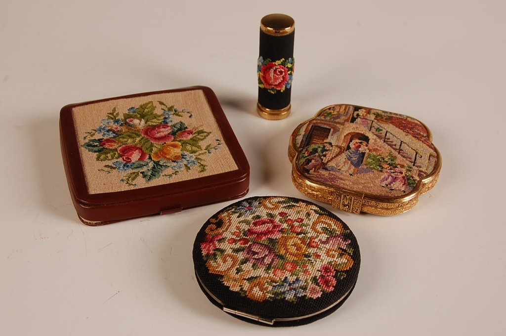 THREE PETIT POINT COMPACTS & A LIPSTICK: Petit point compact with a village scene, goldtone frame, mirrored lid, mesh sifter and puff, unmarked, measures 3 x 3 inches, silvering loss to the mirror, good overall. Petit point compact with a fl
