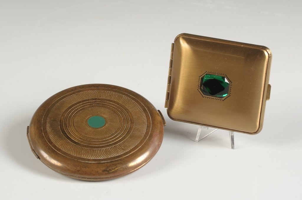 MONDAINE JEWELED VANITY CASE & VINTAGE COTY COMPACT: Mondaine goldtone compact with a green jewelry on top, framed mirror in the lid, hinged powder well with puff, hinged rouge and lip rouge well with pans an a puff, marked on the rouge well lid, measur