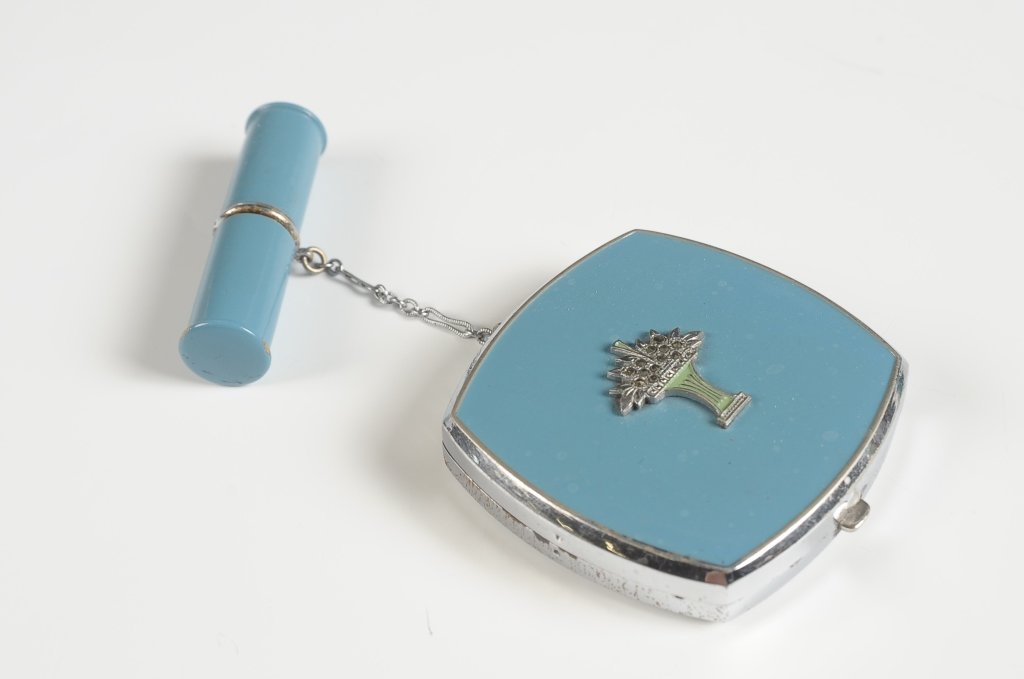 EVANS ENAMEL COMPACT W MARCASITES & LIPSTICK FOB: Evans Tap-Sift blue enamel duo compact with a flower vase decoration in enamel and marcasites, chain handle with an enameled lipstick fob, hinged metal mirror over a rouge well in the lid with pan, ba