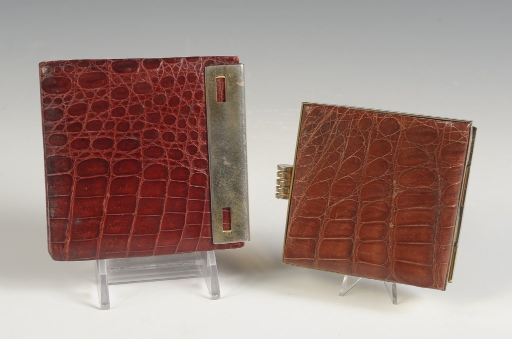 TWO ALLIGATOR LEATHER COVERED COMPACTS: One Argentinean compact with slide out mirror clasp and folded leather powder well with puff and mesh sifter, measures 3.25 x 3.25 inches, very good. And a smaller alligator compact with goldtone fram