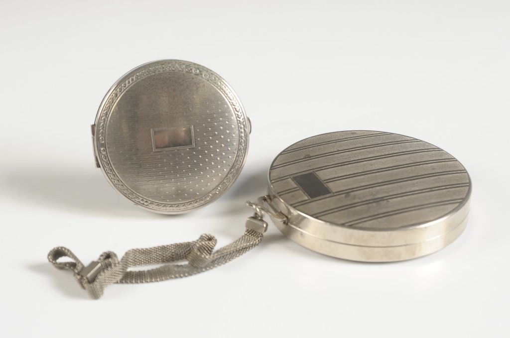 1924 VANITY CASE & RICHARD HUDNET DEAUVILLE COMPACT: Silvertone vanity case with mesh chain handle, framed mirror in the lid, base holds a lipstick, rouge and powder wells with pans and puffs, patent dated 'Feb.12.24', measures 2.75 inches, good. And a 
