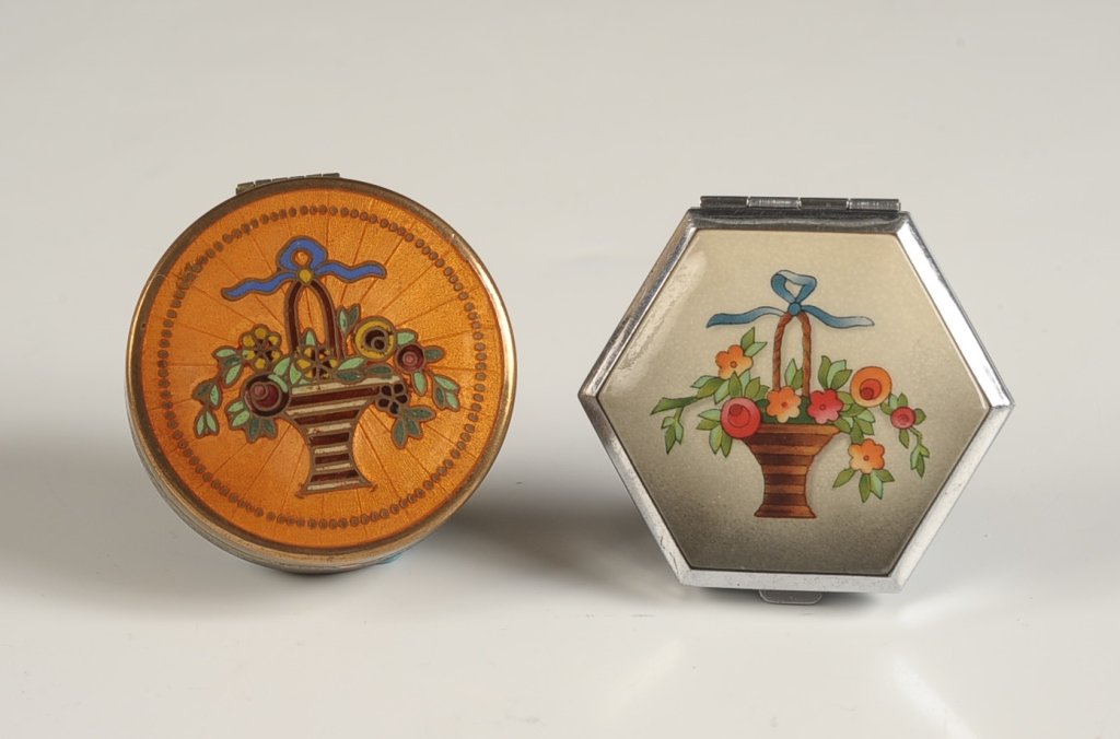 TWO HOUBIGANT COMPACTS WITH FLOWER BASKET MOTIFS: French. Champleve enamel compact top on a goldtone base, framed mirror in the lid, empty powder pan insert present, marked on the bottom of the pan, measures 2 inches, base is oxidized, enameling is v