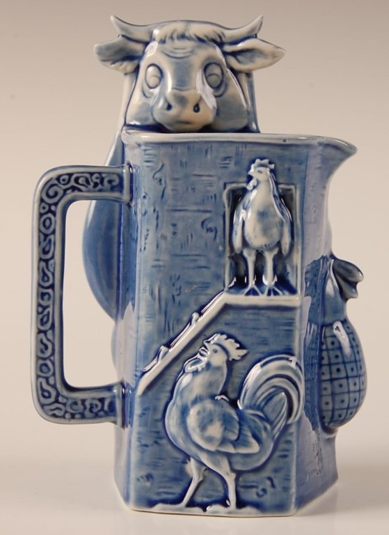 SCHAFER AND VATER FIGURAL COW & MILK MAID CREAMER: Blue glaze, unmarked, measures 5.5 x 4 inches. Please note that this item will be shipped by our in-house shipping department and is subject to a 14 day return policy guarantee. If any piece in this l