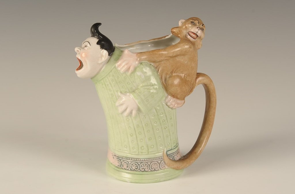 SCHAFER & VATER MAN W MONKEY ON HIS BACK CREAMER: Color glaze, faint impressed mark, measures 5.5 x 5 inches. Please note that this item will be shipped by our in-house shipping department and is subject to a 14 day return policy guarantee. If any pi