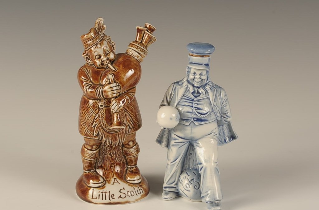 SCHAFER & VATER SCOTCH BAGPIPER & GUT HOTZ FLASKS: A Little Scotch' bagpiper flash in brown glaze, unmarked, measures 7 x 3 inches. Plus a 'Gut Hotz' tophat man in blue glaze, impressed mark, measures 5.5 x 3.25 inches.Please note that this item will 