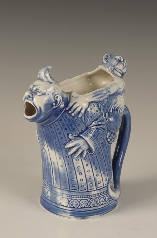 SCHAFER & VATER MAN W MONKEY ON HIS BACK PITCHER: Blue glaze, impressed mark, measures 6.25 x 6 x 3.5 inches. Please note that this item will be shipped by our in-house shipping department and is subject to a 14 day return policy guarantee. If any pi