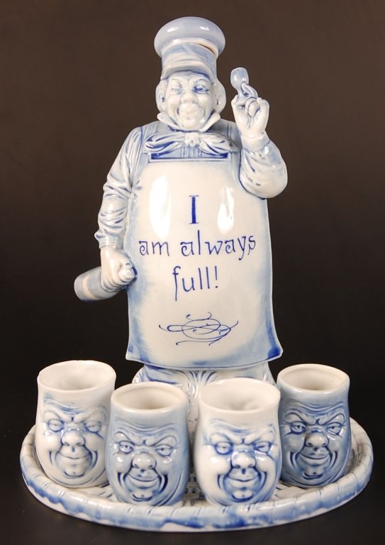 SCHAFER & VATER BAKER FLASK WITH TRAY AND CUPS: Blue glaze baker flask 'I Am Always Full', no maker's mark, measures 8 inches. Oval tray with blue glaze, unmarked, measures 6.25 x 5.5 inches. Plus four happy and angry face cups in blue glaze, unmar