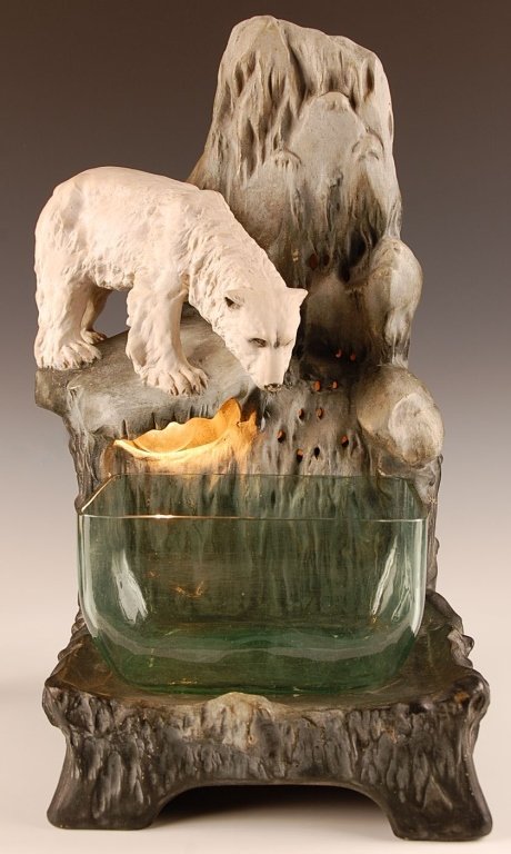AUGUST OTTO FISH BOWL STAND WITH POLAR BEAR: Early 20th century, an interior light shows through openings below and around the bear. Signed Aug. Otto on the reverse, measures 19.25 x 11 x 11 inches.