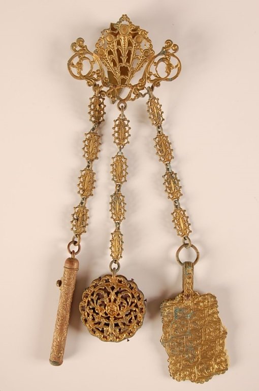 ANTIQUE BRASS FILIGREE CHATELAINE: With a brass mechanical pencil, a pin cushion and a celluloid leaf notepad. Measures 8 x 3 inches.
