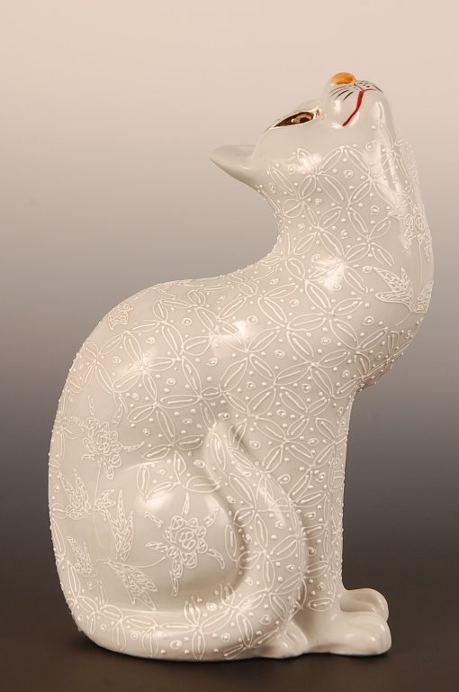 A 12-INCH HIGH JAPANESE KUTANI PORCELAIN CAT: Circa early 20th century porcelain figure with white-on-white design, a signature under the base, this piece measures 12.25 x 5 x 8 inches.