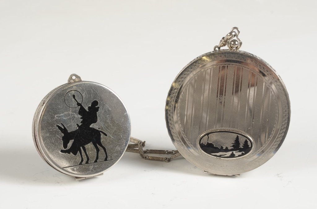 STERLING AND .800 SILVER COMPACTS: Small sterling duo compact with hinged mirror over a rouge well in the lid with pan and puff, powder well with pan and puff, marked on the mirror frame, measures 2 inches, weighs 2.2 ozt. Larger vanit