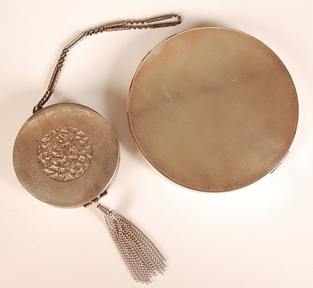 LARGE KARNEE & FILIGREE COMPACTS: Both silvertone and unmarked, filigree compact including chain and tassel 9.5 x 2.5 inches, large Karnee measures 4 inches.