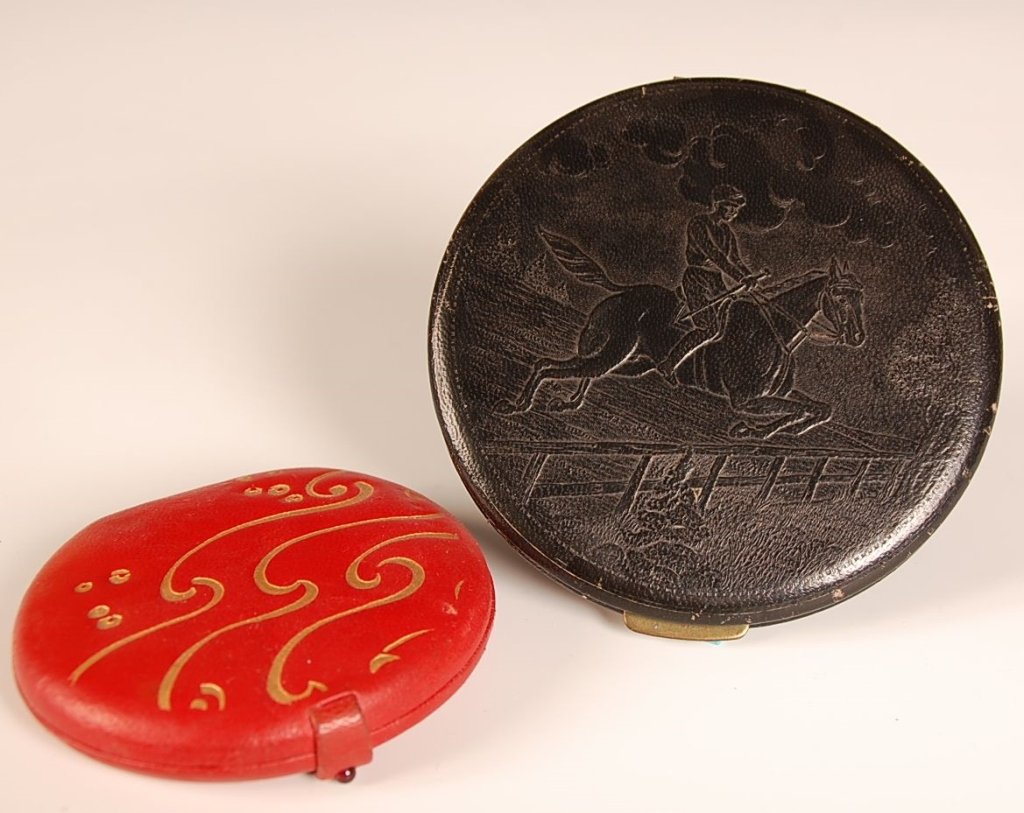 MARCEE & REX FIFTH AVENUE LEATHER COMPACTS: Marcee red leather compact with gold embossed designs, paper label stating 'Genuine Leather Hand Made', fitted and branded puff and sifter, measures 3.5 x 3.75 inches, silvering loss to the mirror, te