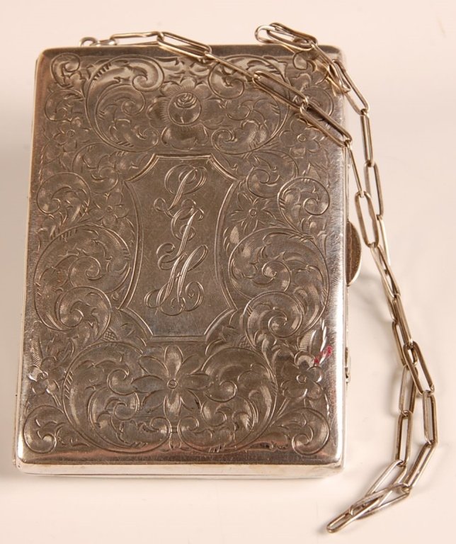 1916 HAND CHASED STERLING MINIAUDIÈRE: Chain handle, monogrammed on top, dated 1916 on the bottom, hinged mirror in the lid over a writing pad with mechanical pencil and a cigarette case, base holds two hinged wells, one with a change hold