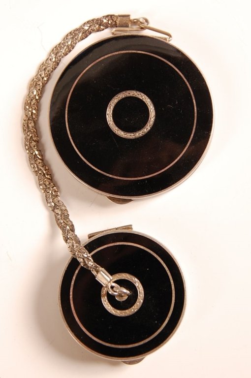 STERLING & ENAMEL COMPACT WITH ROUGE FOB: Black enamel on sterling with a hand chased design, chain handle with a rouge compact fob, framed mirrors in both compacts, marked on the rims, rouge compact measures 1.5 inches, powder compact measur