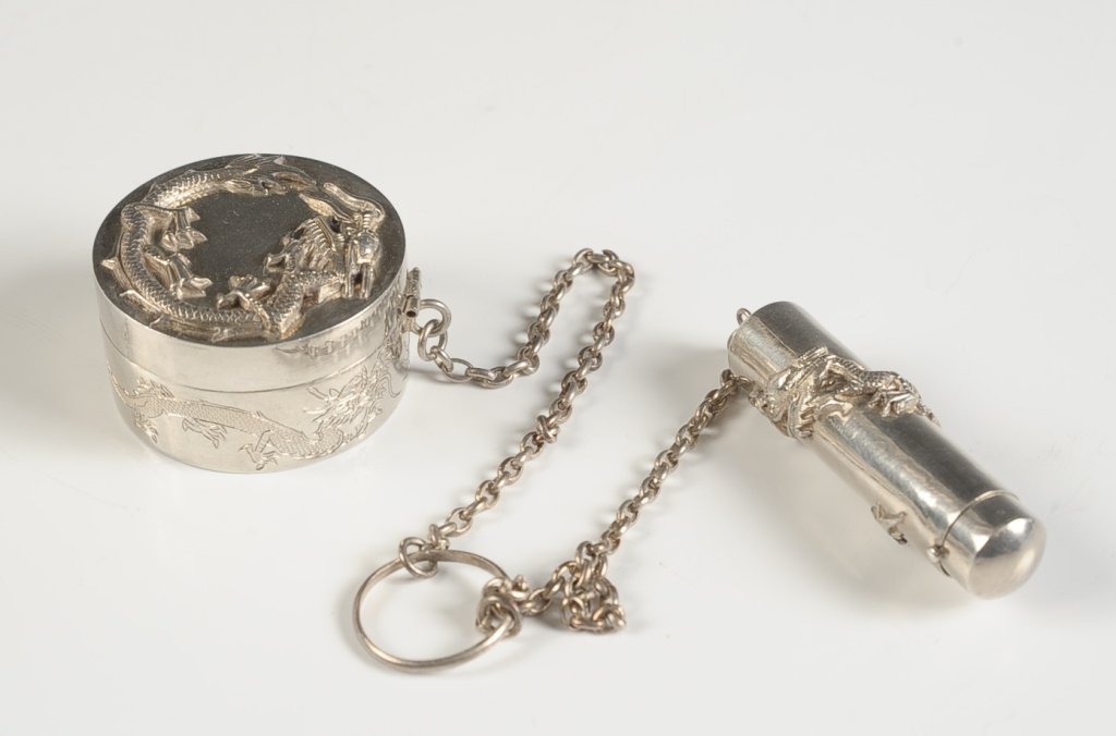 LIPSTICK AND COMPACT PAIR WITH CHINESE DRAGONS: On chains with finger ring, bas relief Chinese dragons on both pieces, framed mirror in the lid of the compact and marked on the bottom in Chinese characters, lipstick measures 2.25 inches in length,