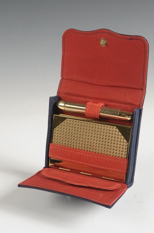 VINTAGE COTY VANITY SET WITH FAILLE SLIPCASE: Goldtone book style compact with a mirrored lid, hinged powder well with branded puff, marked on the powder well lid, with a double sided lipstick and perfume combo, all in a navy faille slipcase with