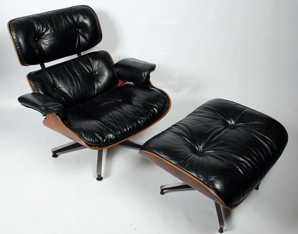 CHARLES AND RAY EAMES LOUNGE CHAIR FOR HERMAN MILLER: Lounge chair and ottoman of Black leather upholstery back and seat cradled in rosewood veneer plywood frame resting on polished and enameled aluminum five-prong propeller base. Ottoman of conforming d