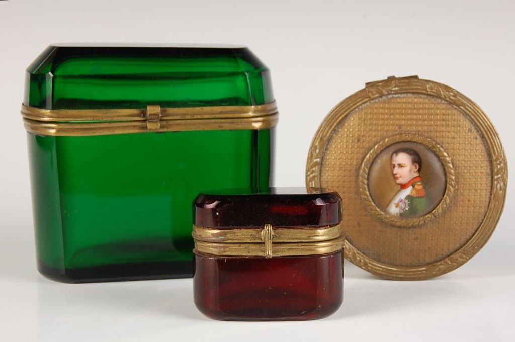 THREE FRENCH BOXES: Green and ruby red glass boxes, along with an ormolu circular box with portrait of Napoleon on porcelain, decal with hand highlights. Group of three pieces ranging in size from 2 x 2.5 inches, up to 4