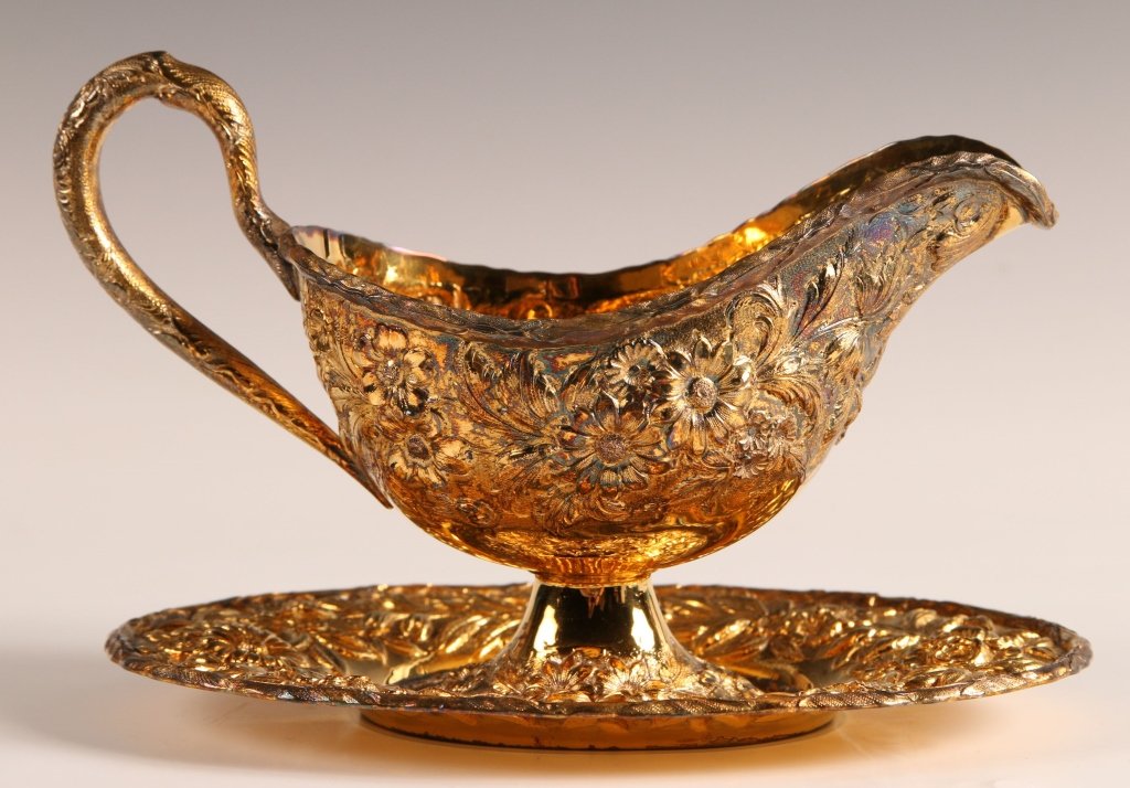 S. KIRK AND SON GILDED REPOUSSE SAUCE BOAT: Sauce boat and under tray, each marked " Hand Decorated S. Kirk and Son Sterling". The sauce boat is numbered 278 F and the under tray 278. The sauce boat measures 5.5 x 8.5 inches, and under tray mea