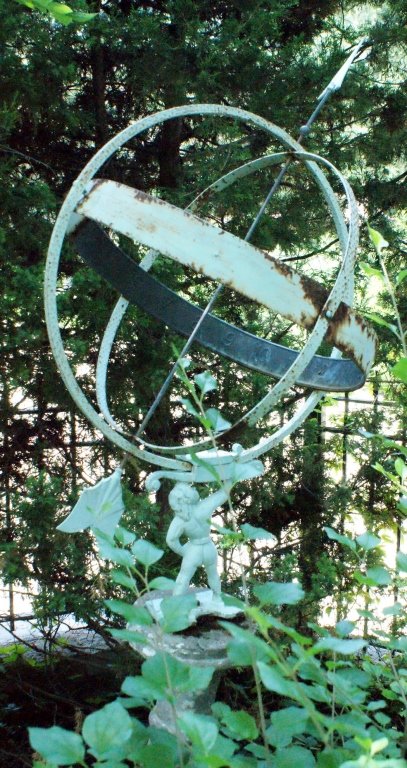20TH CENTURY ARMILLARY SPHERE ON CONCRETE PEDESTAL: The concrete pedestal measures 40 inches high, the entire ornament measures 76 inches high, the sphere measures approximately 20 inches across.