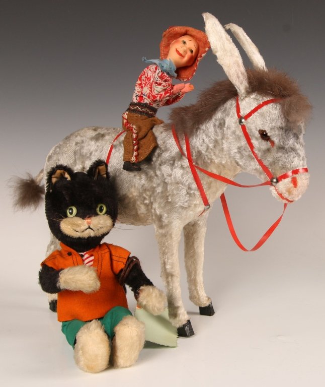 VINTAGE MECHANICAL DONKEY & CIRCA 1950 SCHUCO CAT: Wind-up mechanical donkey with rider, rabbit fur mane and tail tuft, tail and ears wag and rider moves back and forth when wound, no key, rider's back is broken, spots of light wear to the fur, measur