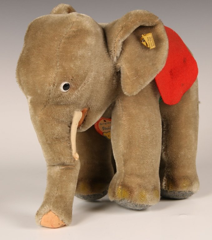 CA. 1968 STEIFF STANDING ELEPHANT 0500/22: With red felt saddle, chest label, script button in ear with yellow label, measures 8 inches (20 cm).