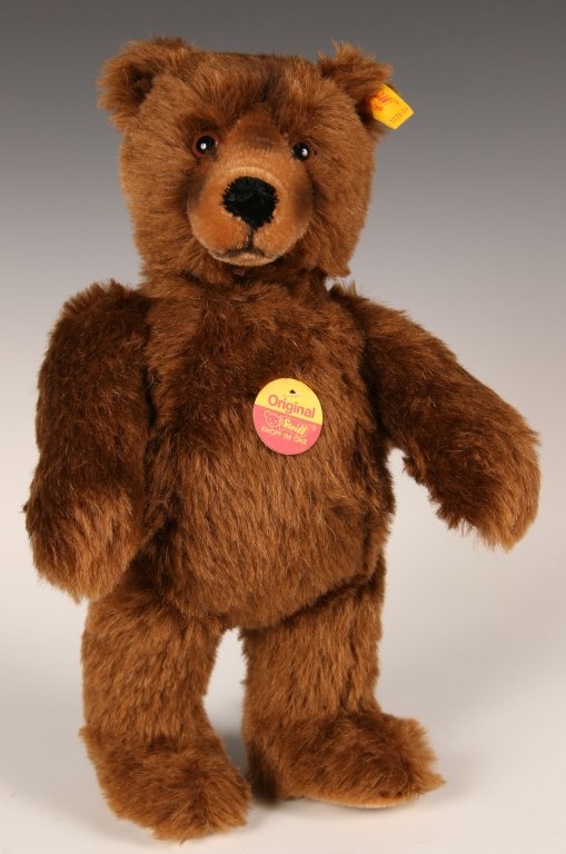 STEIFF ORIGINAL TEDDY BEAR: 0128/34, chocolate brown, button in ear with yellow label, paper chest and hang tags, measures 13 inches (34 cm).