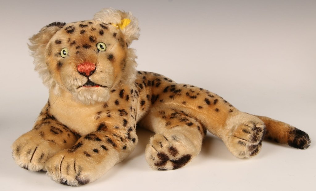 CIRCA 1960 STEIFF LEOPARD, LYING DOWN 2328,1: Glass eyes, vertically stitched nose, script button in ear, yellow label, measures 8 x 14.5 inches (20 x 36 cm).