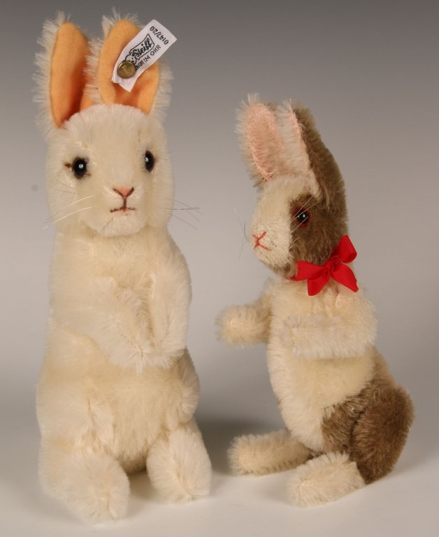STEIFF BEGGING RABBIT 0147/20, PLUS ANOTHER: Steiff standing rabbit, non-jointed, white mohair, glass eyes, script button in ear, white label, no chest tag, measures 10 inches (25 cm) standing. Plus a jointed standing rabbit, brown and white moh