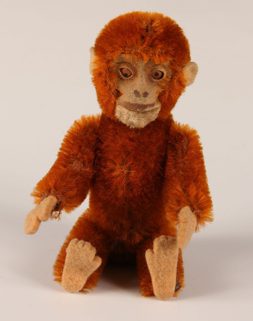 CIRCA 1930s SCHUCO MONKEY PERFUME: Red gold mohair, felt face, paws and ears with glass eyes, jointed body and removable head with glass perfume vial, measures 5 inches.