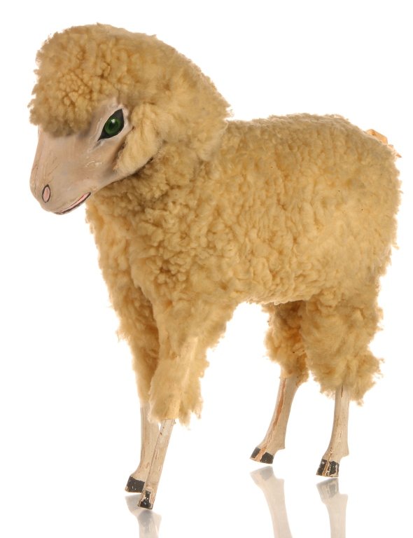 A 12 INCH GERMAN PAPIER MACHE SHEEP WITH VOICE BOX: A rare and large German figure with wooly legs, papier mache face, glass eye, and working voice box. Pressing down on the head results in a squeaker-type report as the spring loaded head returns to th