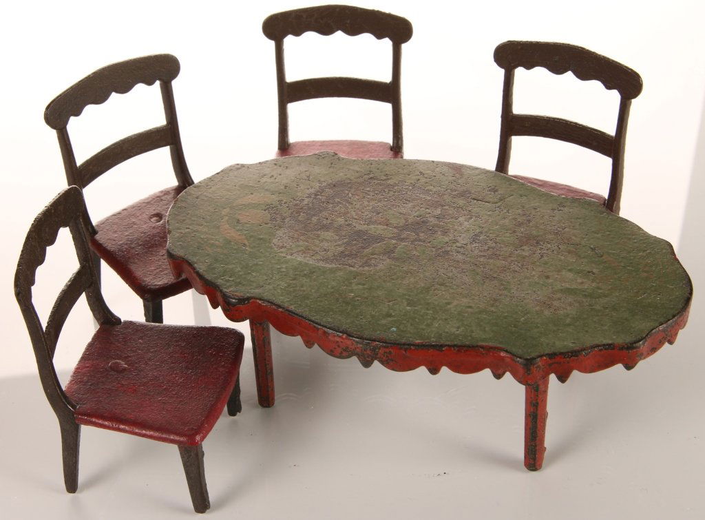 J&E STEVENS IRON DOLL HOUSE KITCHEN TABLE AND CHAIRS: Attributed to J&E Stevens toy company, Cromwell, CT. Pictured in their catalog as No. 103 kitchen chairs. Group of five pieces, including four small chairs each measuring 3.5 x 2.25 x 2 inches, and a