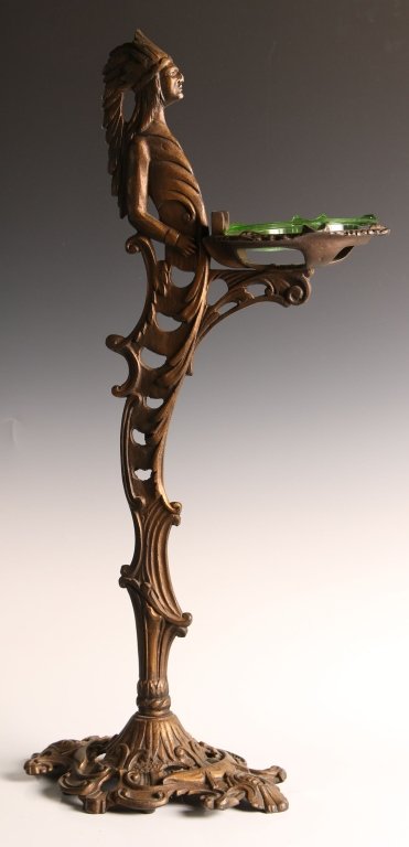 1930s CAST IRON INDIAN FIGURAL ASH RECEIVER: A floor standing ashtray in the form of a Native American with head dress. Measures 30 inches high with a 15 inch wide iron base numbered in embossed lettering on the underside S265. The base is furth