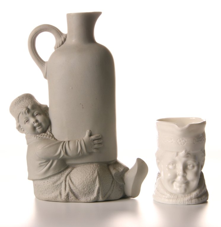 SCHAFER & VATER DUTCHMAN CREAMER AND FLASK: Dutchman's head creamer in white glaze, impressed mark, measures 3 inches. Plus an unglazed Dutch boy with a bottle flask, impressed mark, no stopper, measures 7.5 inches.