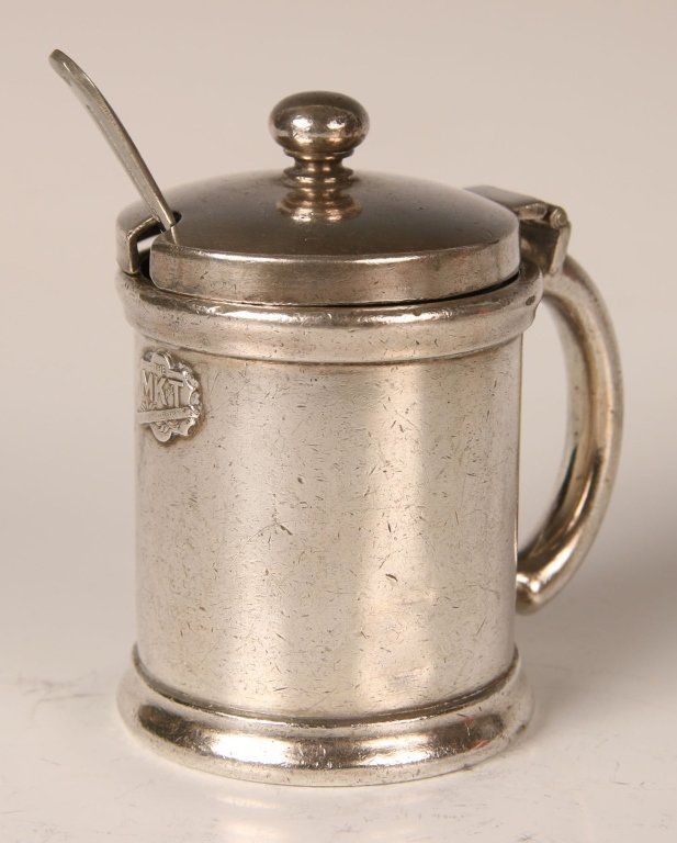 MISSOURI KANSAS TEXAS RAILROAD SILVER MUSTARD POT: Base marked 'GM CO EP, 03232,' applied MK&T shield to side. With glass insert and small nickel silver spoon. Measures 3.5 x 3 inches.