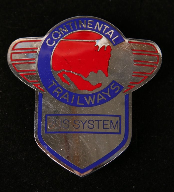 CONTINENTAL TRAILWAYS BUS SYSTEM CAP BADGE: Bright silver toned badge with red and blue enameling, 'Bus System' below, measures 2.5 x 2.25 inches overall. Double screwback, good overall.