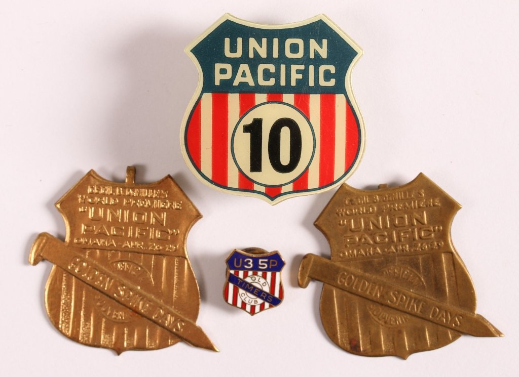 FOUR UNION PACIFIC WAITER AND SOUVENIR BADGES: Includes a celluloid shield logo badge for dining car waiter number 10, 1.5 x 1.5 inches. Also two badges for the world premier of Cecil B. DeMille's 'Union Pacific' a the Omaha 'Golden Spike Days' in