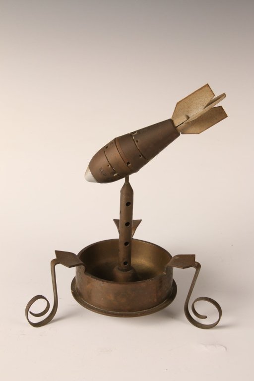 WWII JAPANESE TRENCH ART ASHTRAY: Shell casing base with ornate curled legs, central shaft with small mortar atop a central shaft. Measures approximately 7.5 x 6.5 inches.