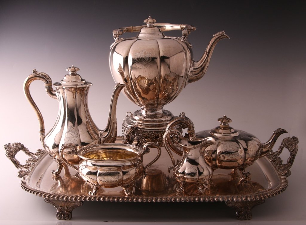 ENGLISH TEA & COFFEE SERVICE ON A SHEFFIELD PLATE TRAY: Date marks circa 1840, London hallmarks, family crest on the sides, tipping kettle measures 14.5 x 11 x 8.5 inches, weighs 66.5 ozt; coffee pot measures 9.5 x 10 x 6 inches, weighs 37.05 ozt.; teapot 